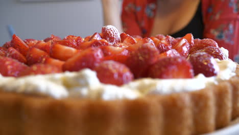 Frau,-Die-Erdbeere-Auf-Köstlichen-Sommerkuchen-Hinzufügt,-Nahaufnahme