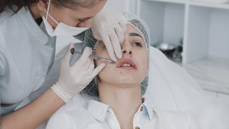 woman receiving lip augmentation injection in a beauty clinic