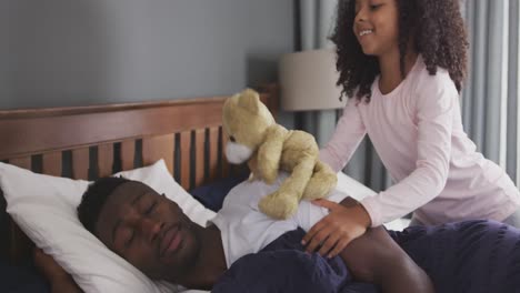 african american girl waking up her father