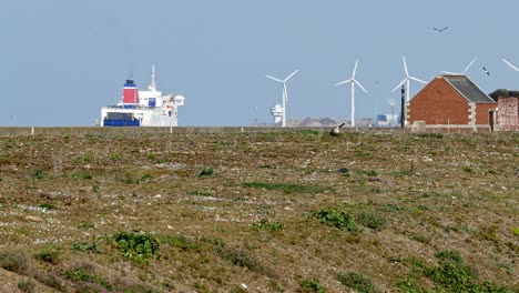 Windturbinen,-Die-Den-Hafen-Drehen,-Und-Ein-Schiff,-Das-Auf-Das-Meer-Hinausfährt,-Erschossen