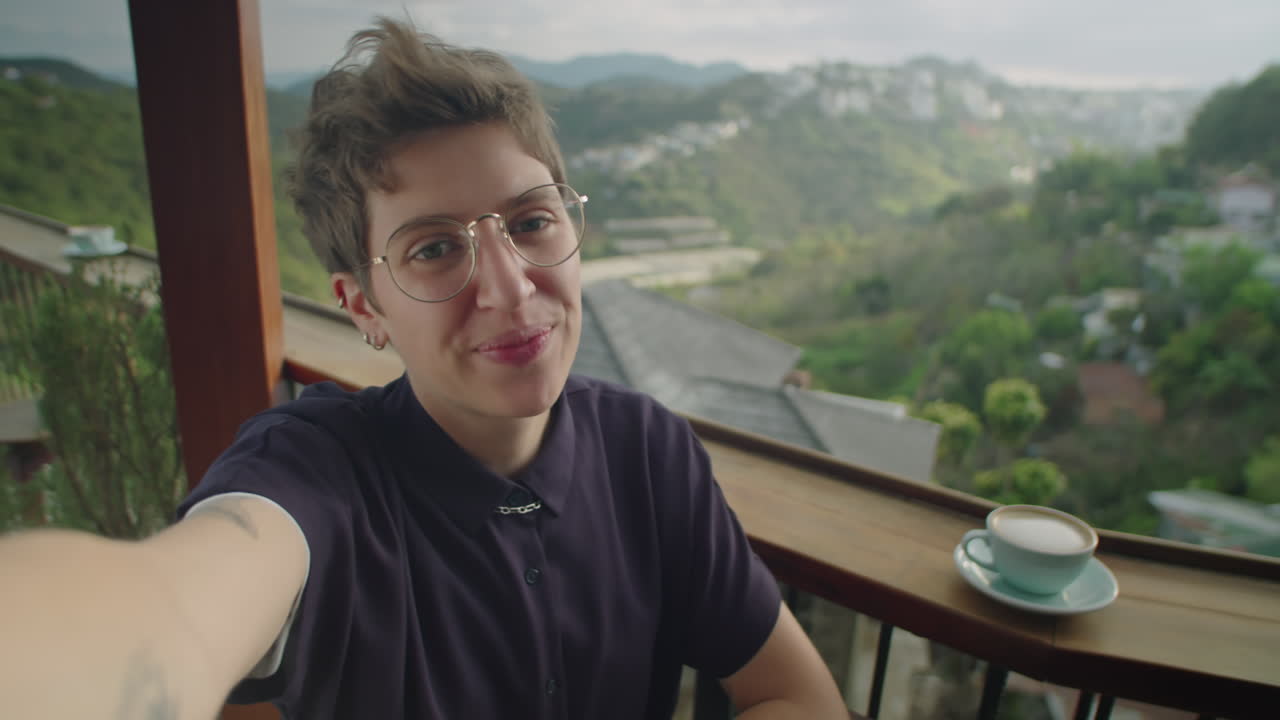 POV di una giovane donna che fa una videochiamata in un bar con vista sulle montagne