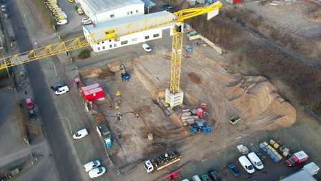 una gran grúa de construcción amarilla y varias máquinas de construcción se utilizan en un sitio de construcción
