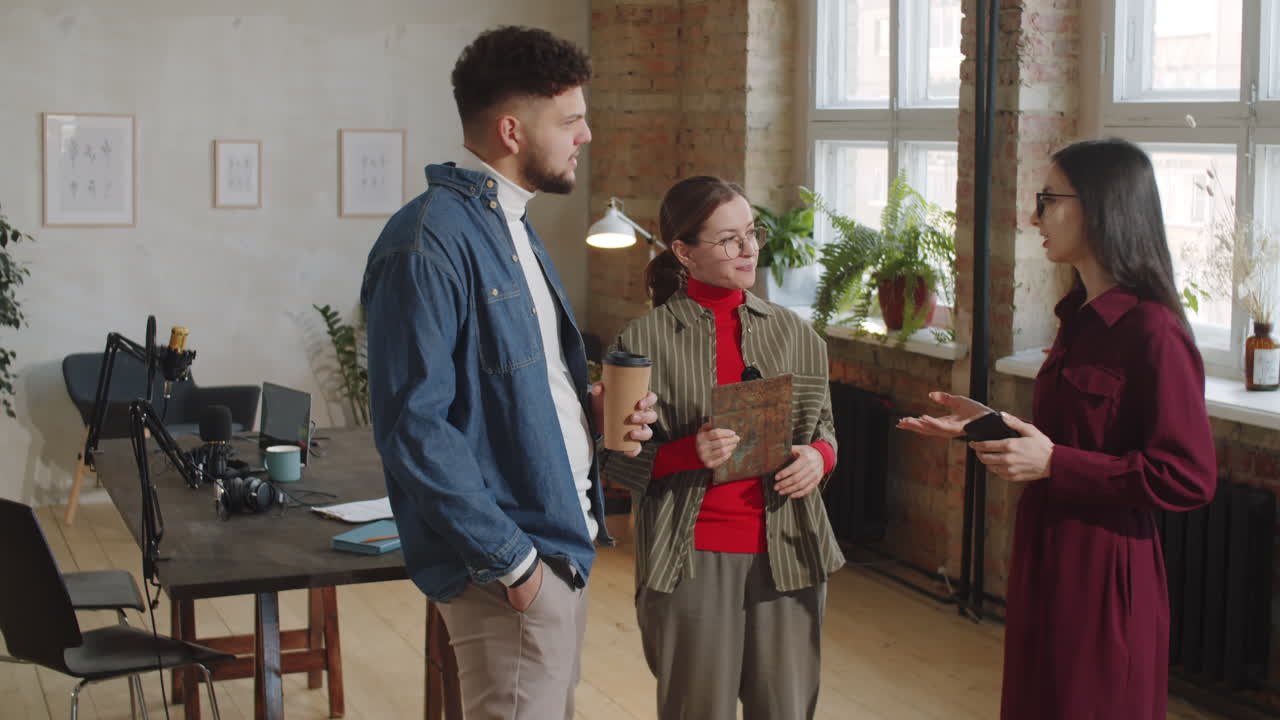 Colleagues Smiling and Talking in Podcast Recording Studio