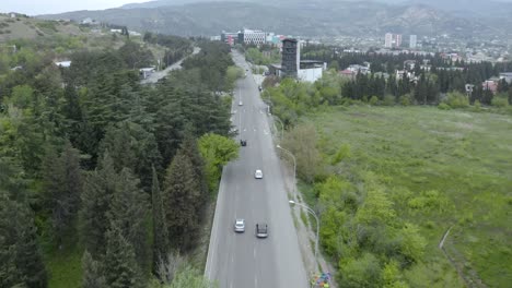 cars driving on the asphalt road in tbilisi, georgia at daytime - aerial tracking shot