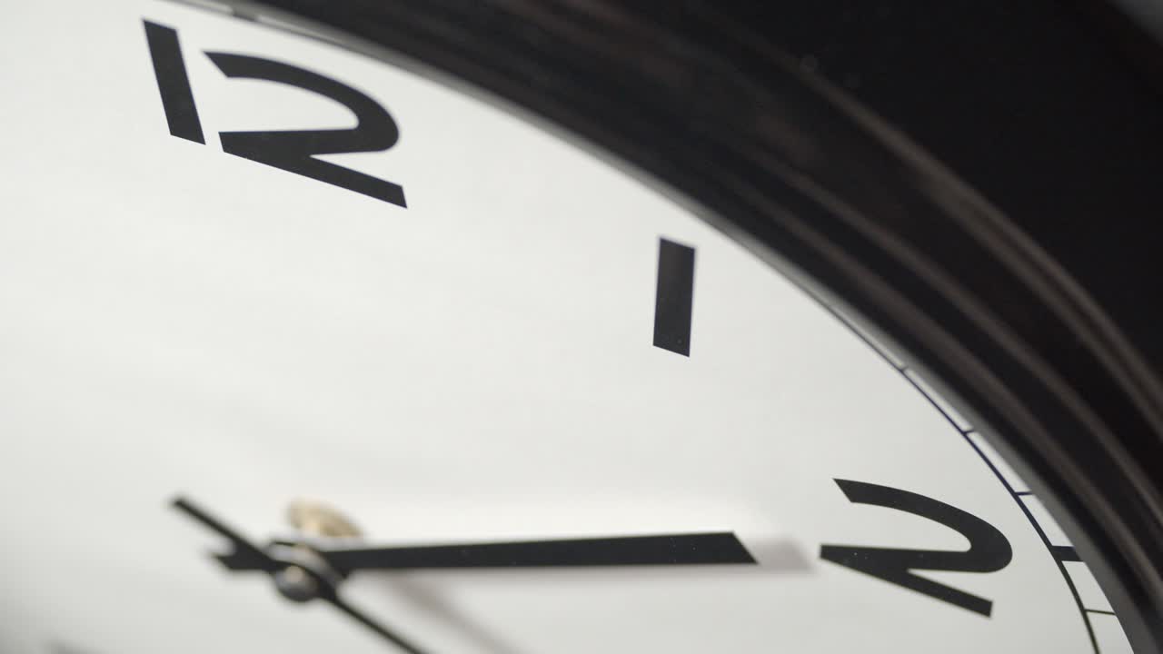 White Clock Face Close Up in Time Lapse on Dark Grey Wall