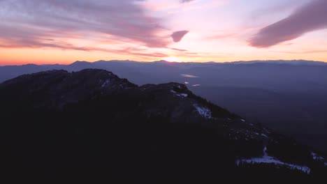 Aerial-view-during-sunset-in-winter-with-snow-on-mountain-peaks-in-Madrid,-Spain