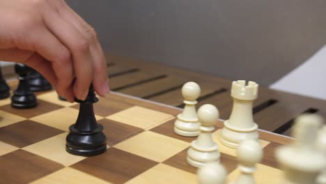 obispo de figura de ajedrez negro en movimiento de la mano capturando la torre blanca, cámara lenta de primer plano