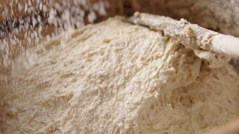 baking - sprinkling a little flour during sourdough bread baking, slow motion