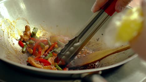 cook prepares fresh vegetables with shrimps in a frying pan then separates shrimp