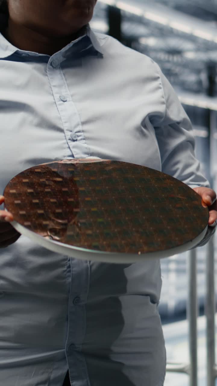 Video verticale: ricercatori che valutano un prototipo avanzato di wafer di silicio per microchip