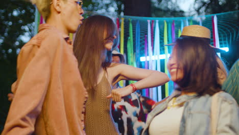 amigos bailando por la noche al aire libre