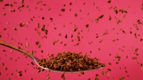 nescafe grains drip onto a metal spoon in a close-up shot against a red backdrop, captured in slow-motion, symbolizing the concept of indulgence and sensory delight