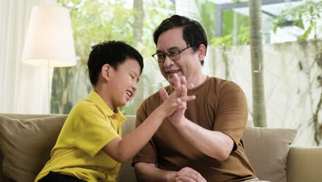 asian man and boy in the living room