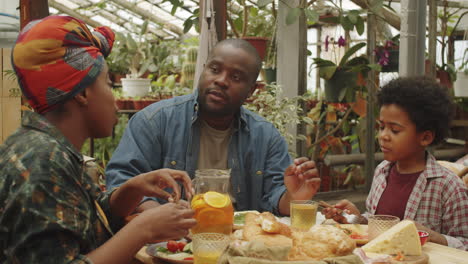 familia afro cenando y charlando en la granja