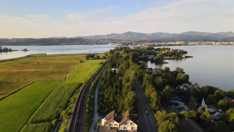 aerial drone shot rising above hurden overlooking rapperswil at sunset in summer