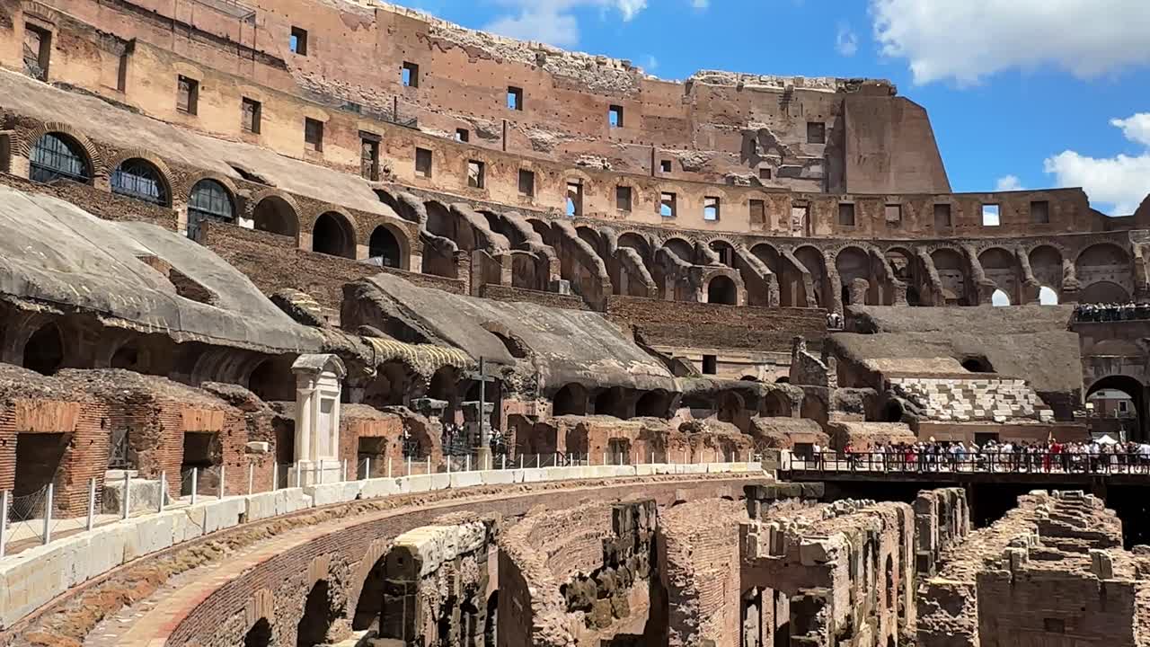 View of the historic Colosseum from inside the ancient amphitheater, tourists take in breathtaking sights