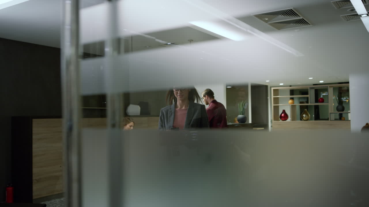 Businesswoman walking office with smartphone. Worker pressing lift button
