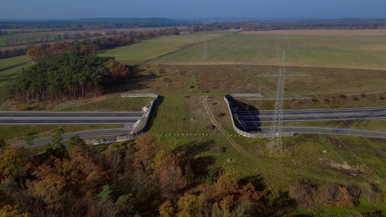 Aerial view showing wildlife crossing over highway in Germany ensuring environmental protection. speed ramp hyper motion time lapse Magic aerial view flight pull in drone