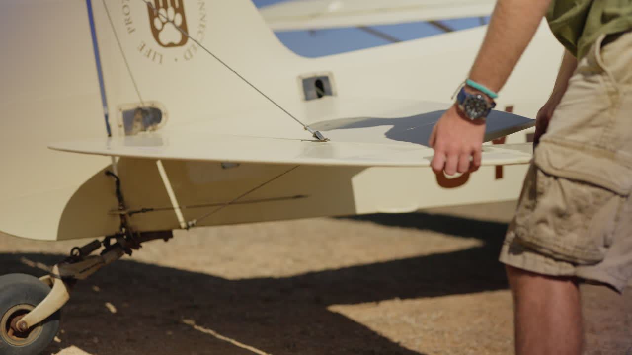 Uomo che ispeziona la superficie di controllo del timone di profondità di un aereo leggero