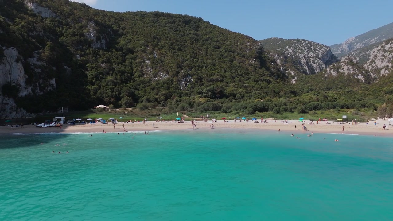 Cala Luna, Sardegna, Italia, acque turchesi e una spiaggia sabbiosa appartata apprezzata dagli amanti del sole, circondata da un aspro paesaggio mediterraneo, vista aerea