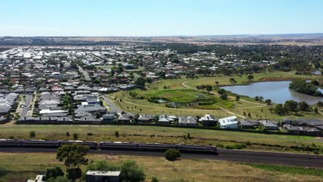 aerial train passes through township with lake a on sunny day