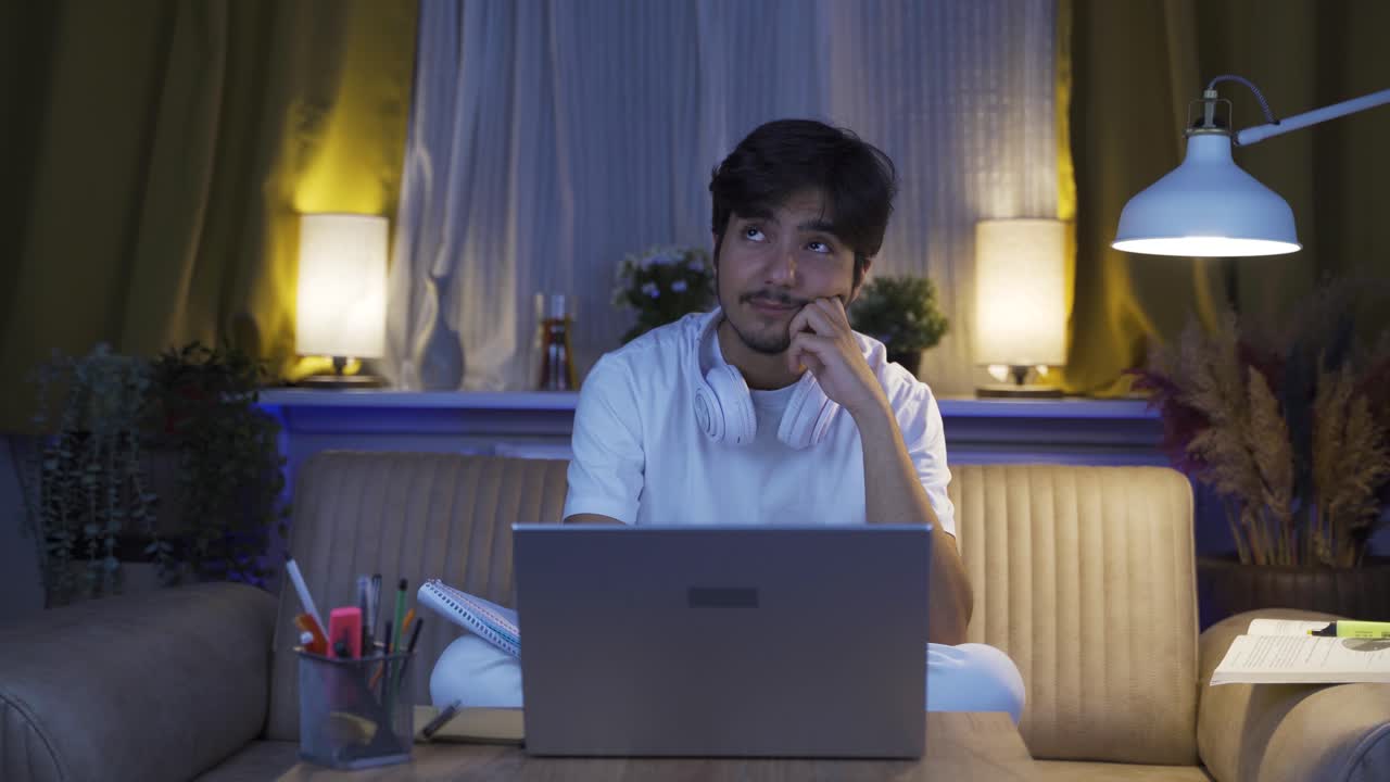 남성 학생은 집에서 밤의 행복한 추억을 기억하고 웃고 있습니다.