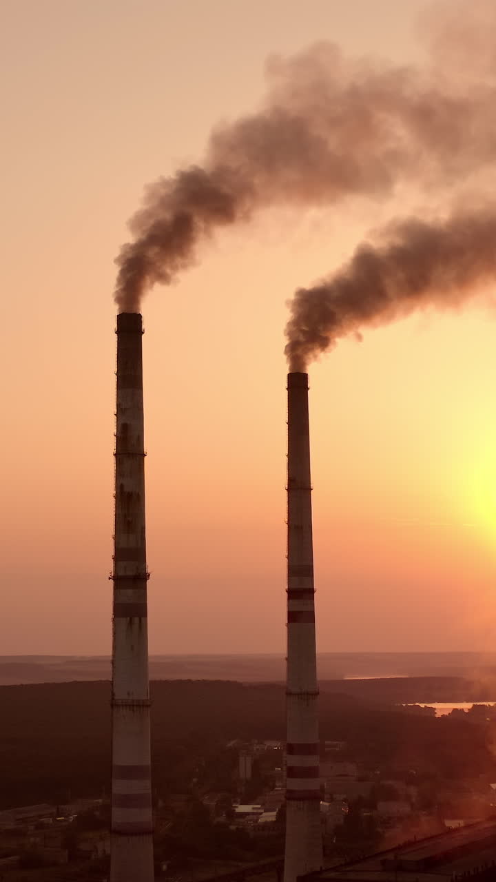 Static view of the power pylons on sunset time background. High voltage electric tower at the sunset. Fabric concept. Selective focus. Vertical video