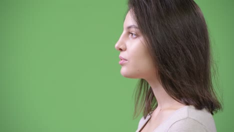 profile view of young beautiful woman against green background