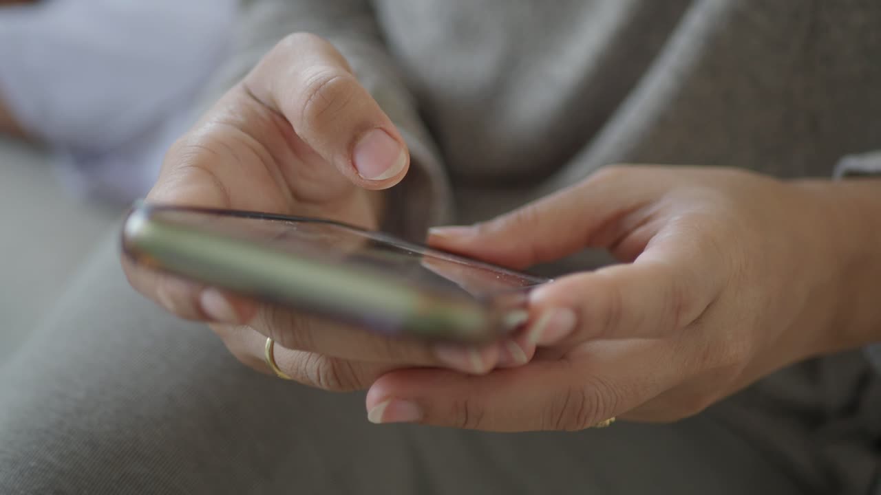 Detailní záběr rukou používajících smartphone, posouvání a psaní