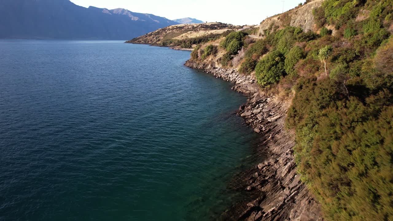 Car Driving On The Road By The Lake Hawea In Summer In South Island, New Zealand. - aerial shot