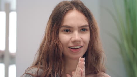 mujer joven haciendo muecas y mirando al espejo en el baño