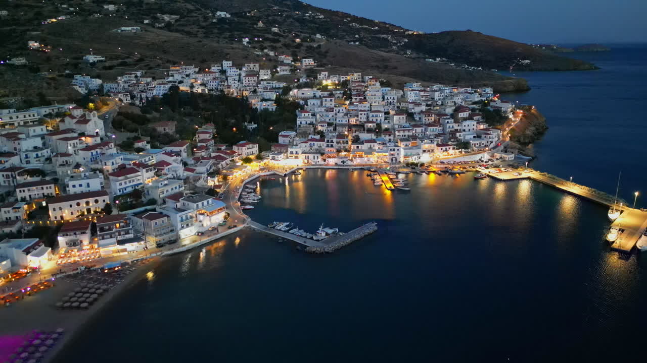 vista aérea del pueblo de batsi con tabernas tradicionales y playa de agua clara, isla de andros, cícladas, grecia, al anochecer