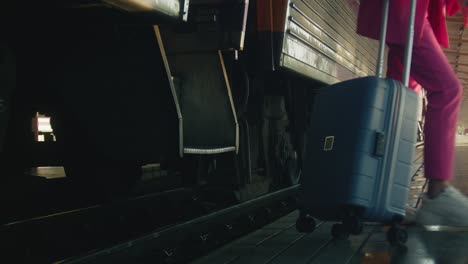 woman boarding a train with suitcase