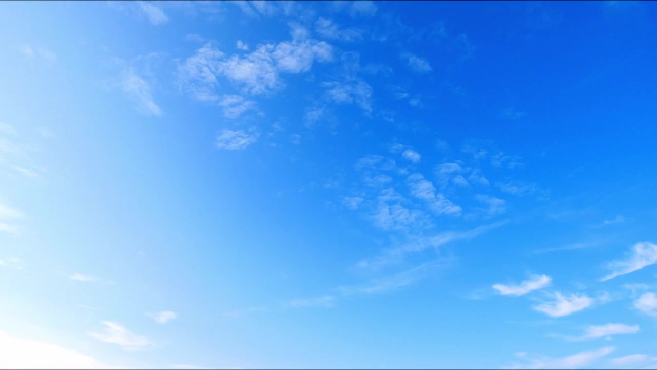 澄み切った青空を雲が流れるタイムラプス。穏やかな屋外の風景の中で、自然な大気の動きと変化する天候を捉える。