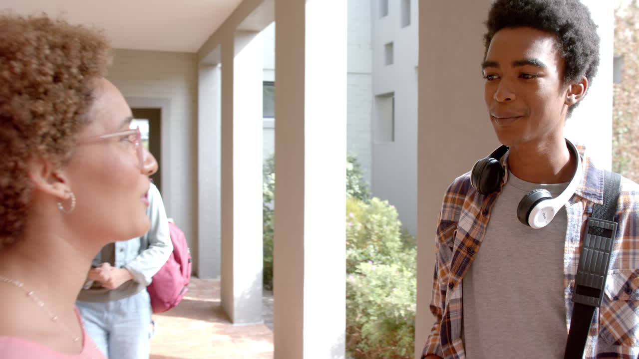 Talking in high school hallway, teenagers smiling and enjoying their conversation
