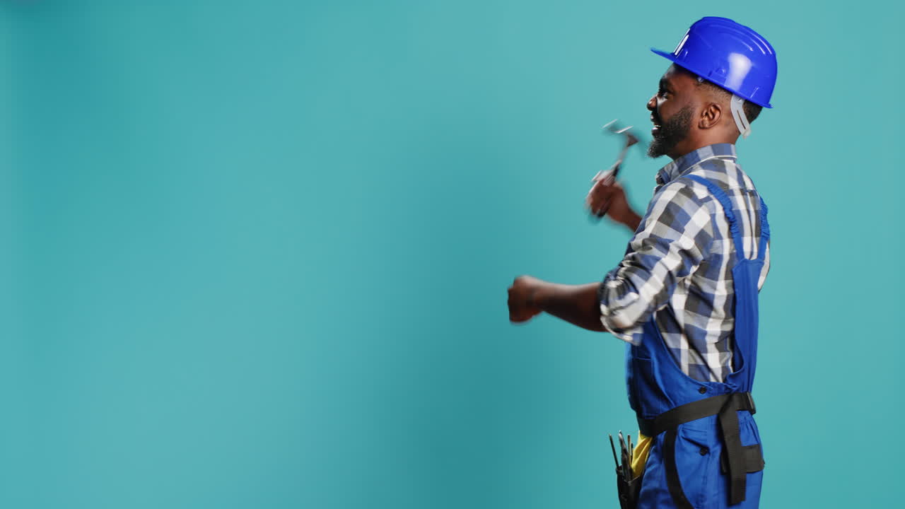 African american carpenter hitting walls with hammer