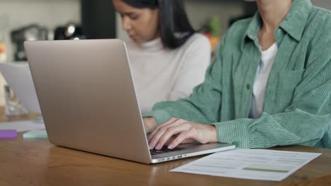 dos mujeres centradas trabajando en la computadora en casa