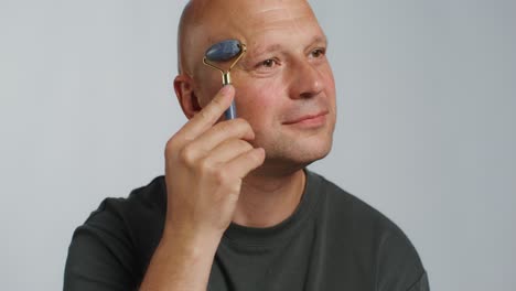 man using a jade roller for facial massage