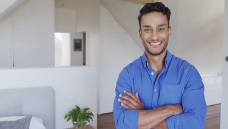 portrait of happy biracial man smiling in modern apartment, copy space, slow motion