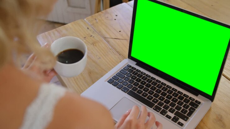 Cute blonde using laptop in kitchen