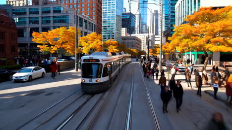city street with tram and pedestrians in autumn