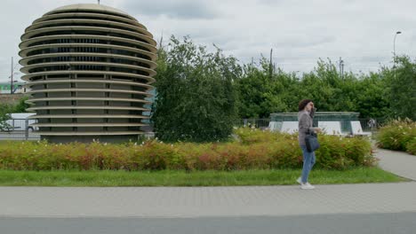 woman walking on city street with modern architecture background