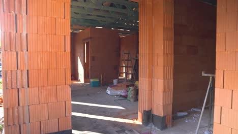 view of unfinished brick house interior with exposed walls and open doorways
