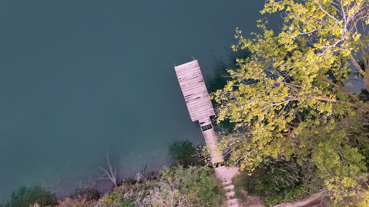 Drone Rotation Over Lago Telese Pier with Transparent Waters and Moving Trees