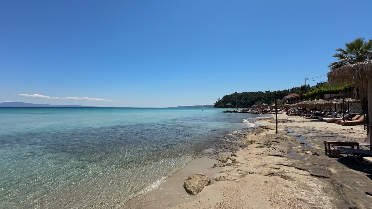 Stunning beach scene in Halkidiki, Greece, with elegant sunbeds facing the crystal-clear turquoise sea. A perfect summer escape in the heart of the Aegean.