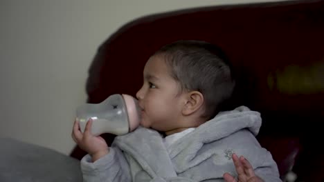 Adorable-Niño-De-18-Meses-Bebiendo-Leche-De-Un-Biberón,-Capturando-Un-Concepto-Atemporal-De-Crianza-Y-Nutrición.