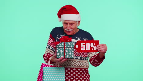 Elderly-man-in-Christmas-sweater-showing-gift-box-and-50-Percent-discount-inscriptions-banner-text