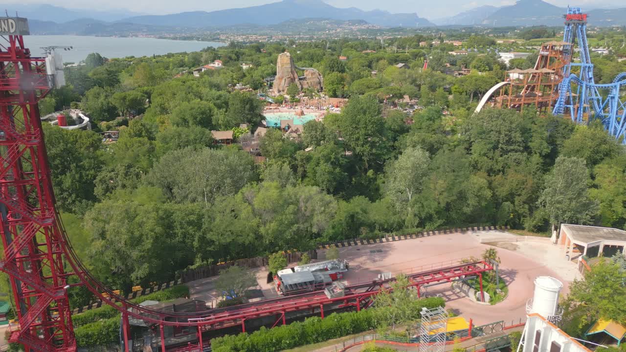 drone sigue el transporte de la montaña rusa rápidamente caer en las vías en el parque de atracciones por el lago de garda italia