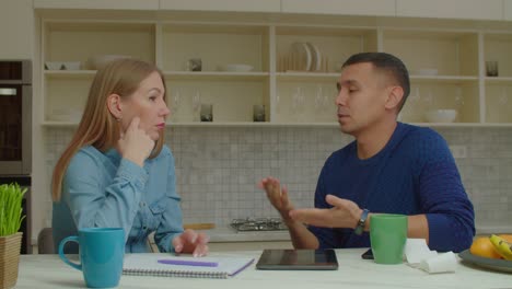 attractive couple with hearing loss managing family finances in kitchen