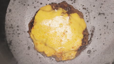 creamy cheese melted on a beef patty while cooking